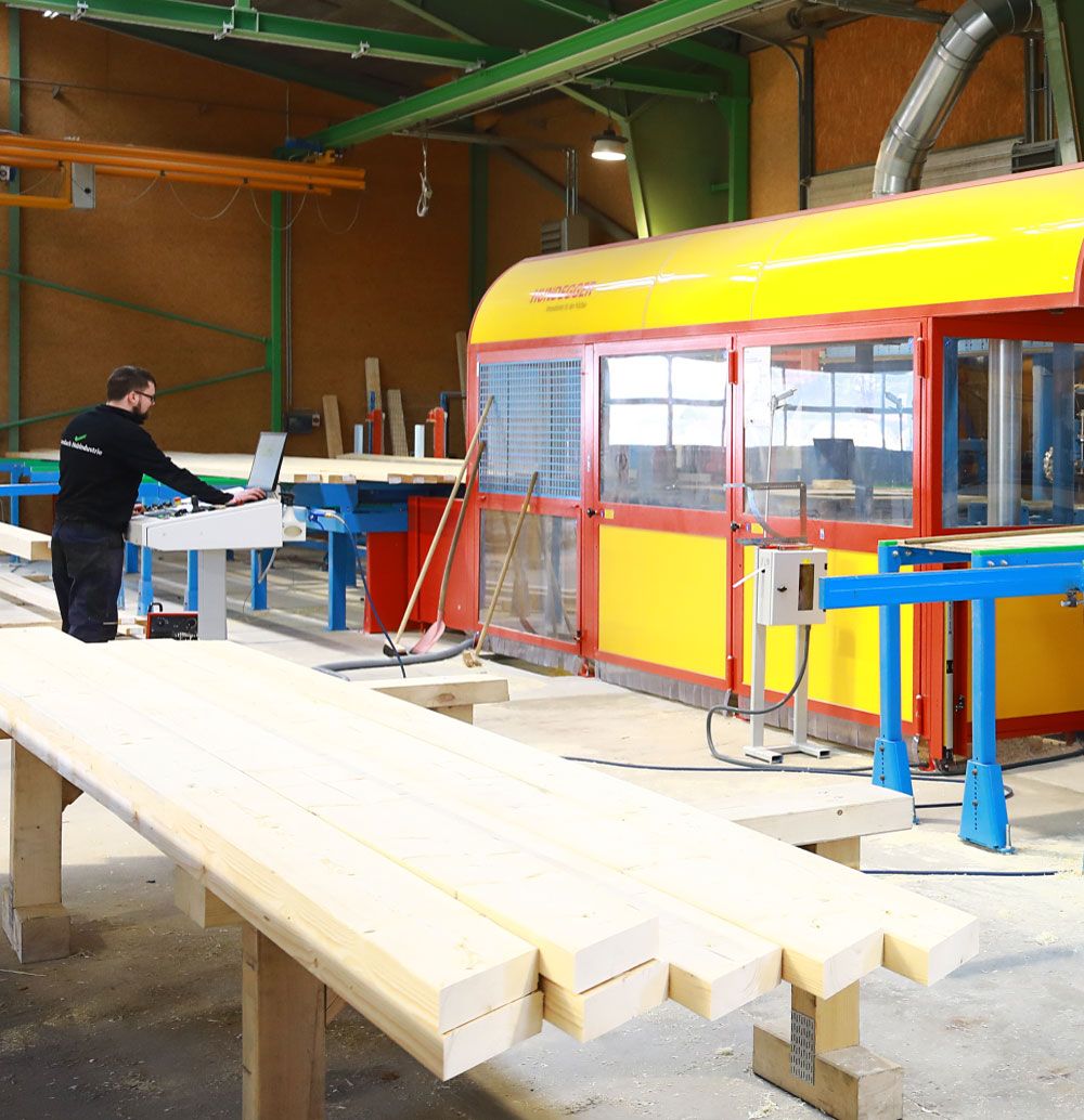Mitarbeiter bedient die K2-Industry von Hundegger - eine High-Performance-Maschine für den Holzbau