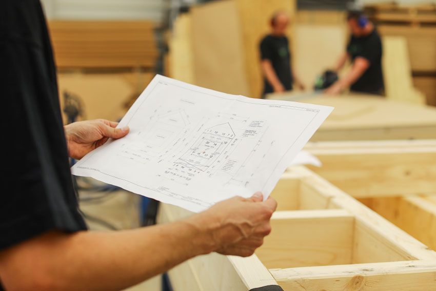 Anhand der Konstruktionszeichnungen fertigen die Mitarbeiter die einzelnen Teilstücke der Holzbauten.